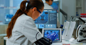 Un'operatrice sanitaria utilizza un tablet per visualizzare dettagli complessi di una cartella clinica elettronica, evidenziando le ultime innovazioni tecnologiche nel campo medico.